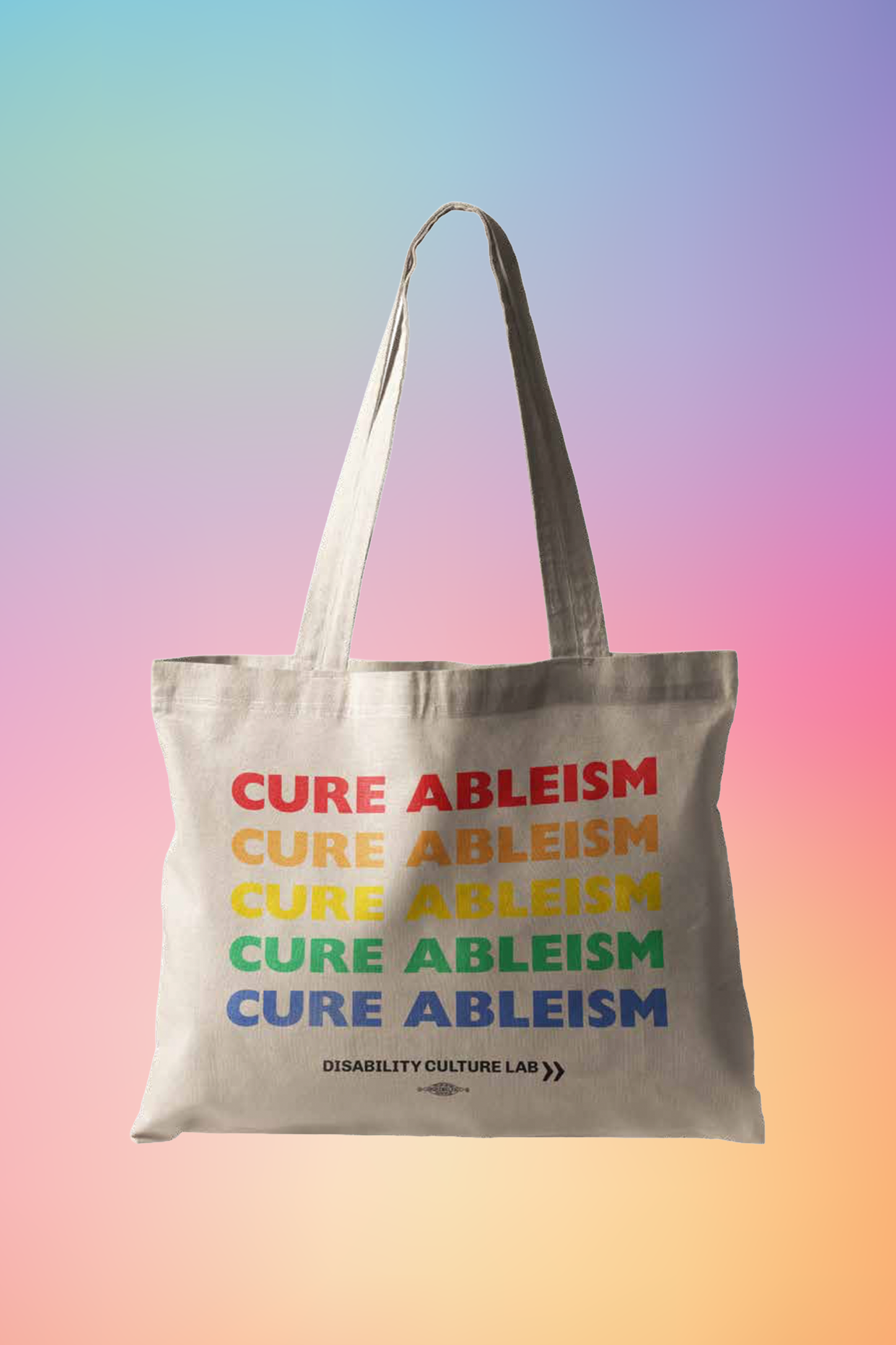 A beige tote bag that reads "Cure Ableism" five times in red, orange, yellow, green, and blue, and the white Disability Culture Lab logo.