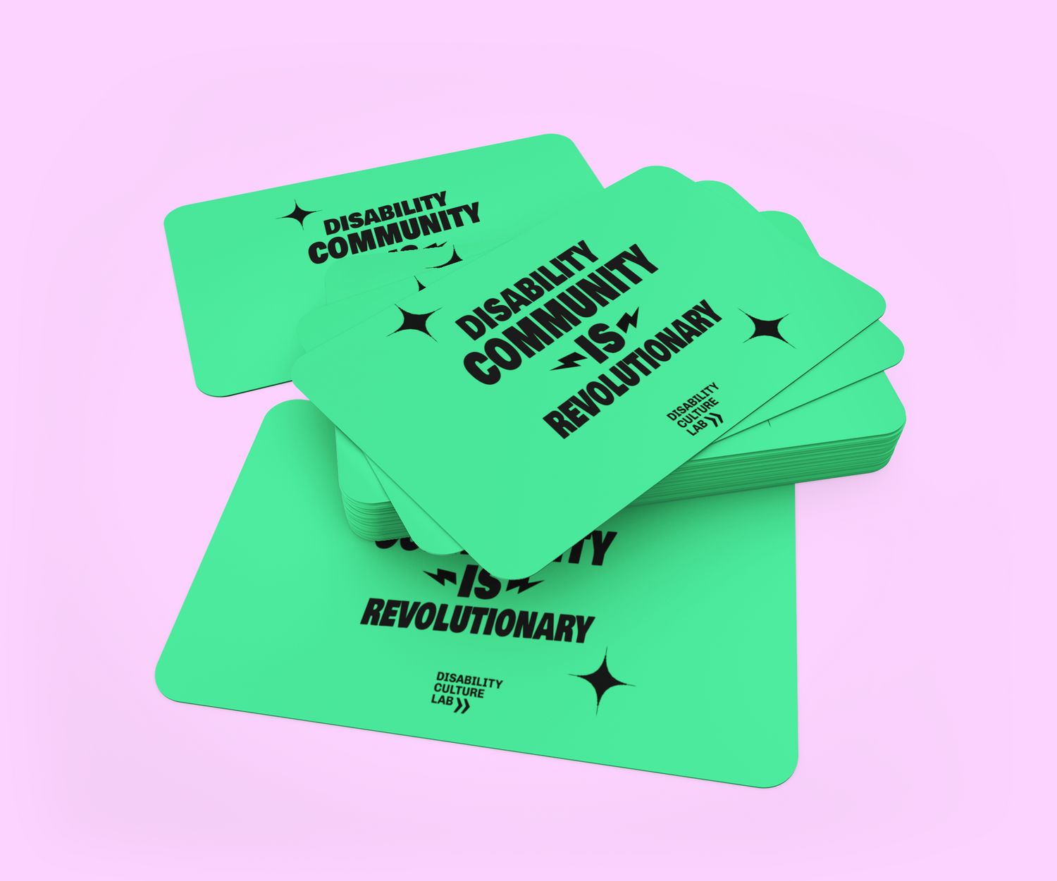 A stack of green cards with the text "Disability Community is Revolutionary" in bold black letters on a pink background.