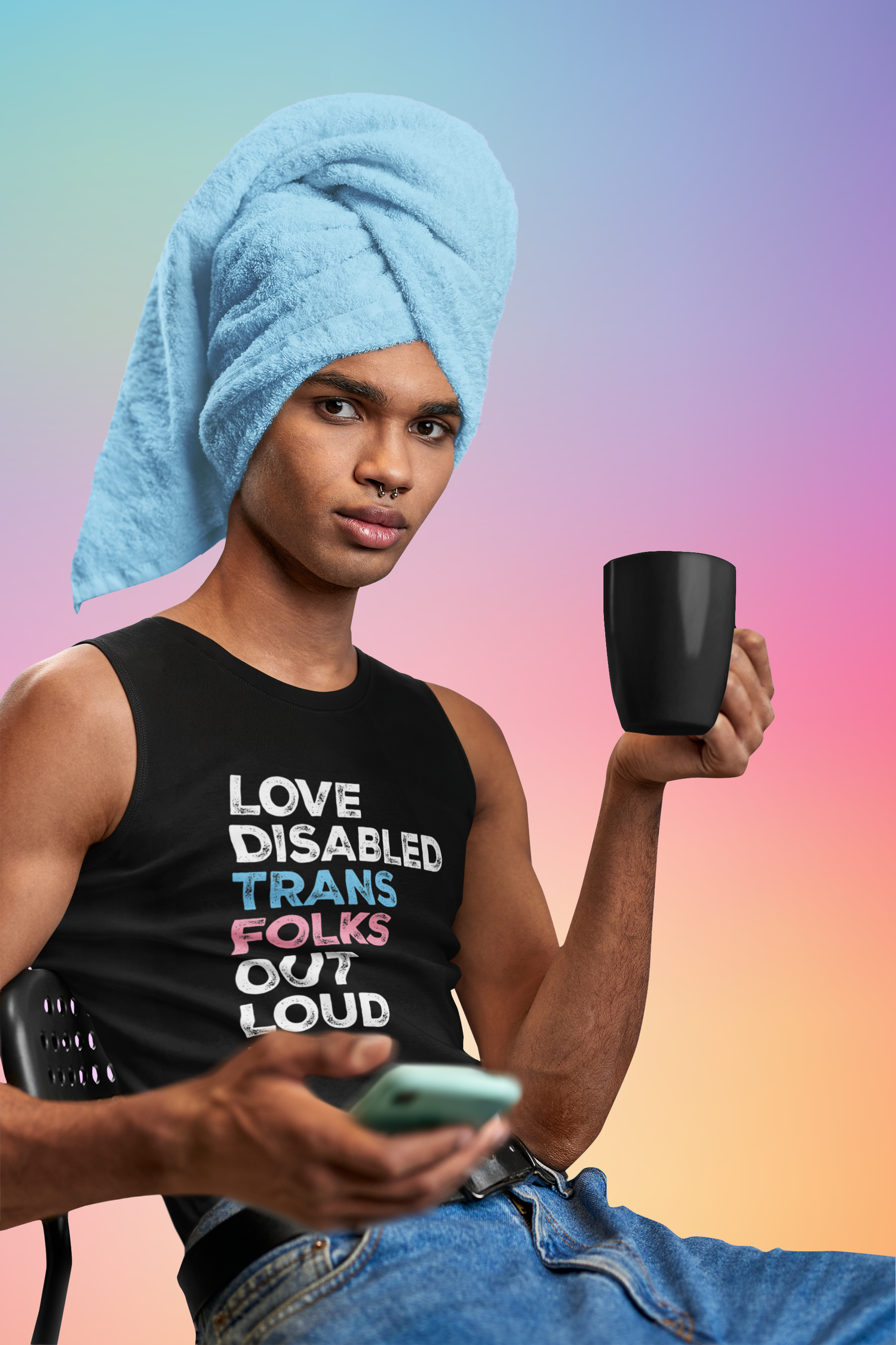A person with brown skin, sitting down with a towel around their head, holding a mug in one hand and a phone in the other. They are wearing blue jeans and a black muscle tank that reads, "Love Disabled Trans Folks Out Loud." The text is in the colors of the trans flag, with "Love Disabled" in white, "Trans" in light blue, "Folks" in light pink, and "Out Loud" in white. Below the design is the white Disability Culture Lab logo.