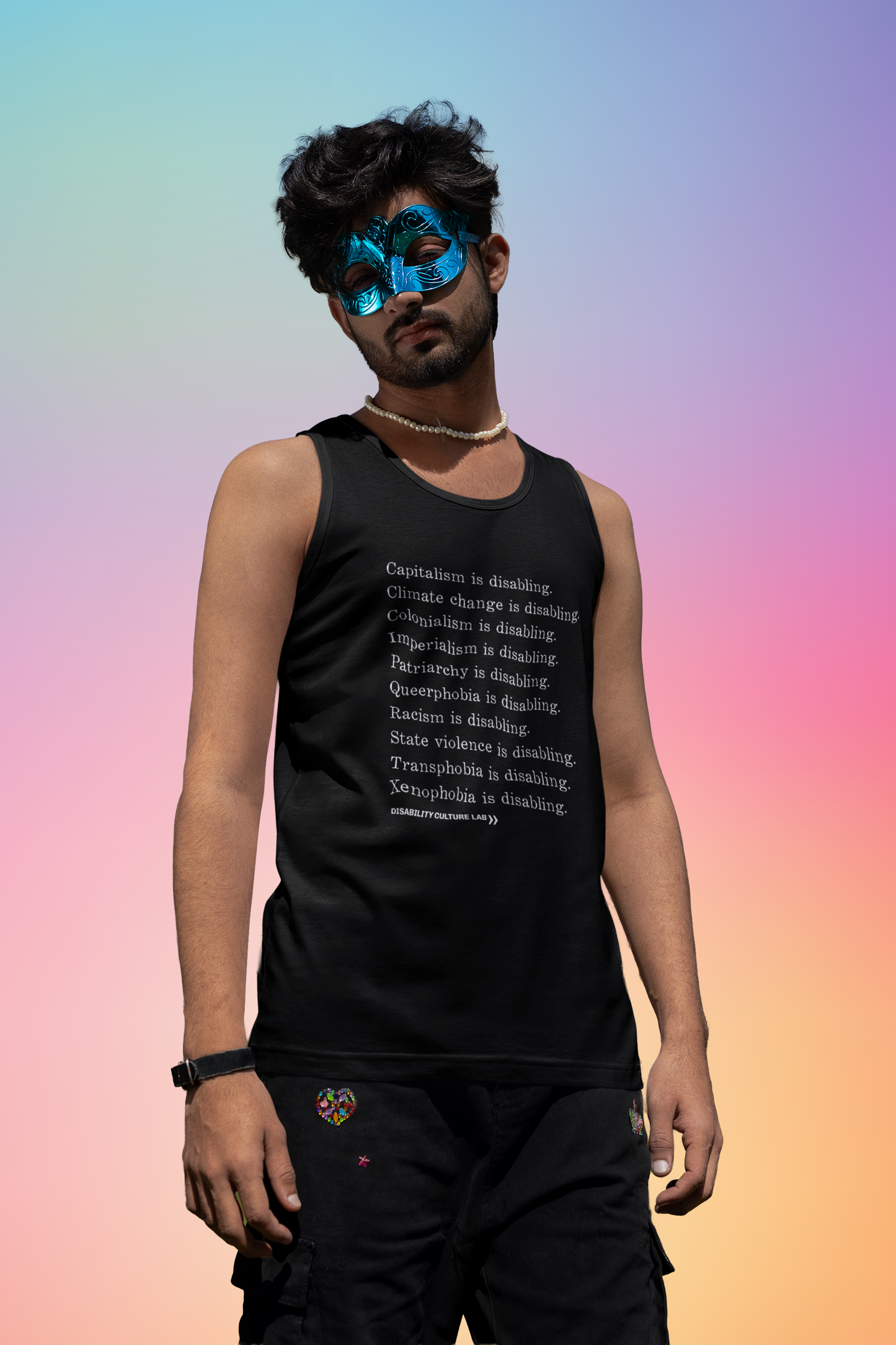 A person with brown skin and short black hair wearing a metallic blue face mask. They are wearing black pants and a black muscle tank with white serif text in a list reading, "Capitalism is disabling. Climate change is disabling. Colonialism is disabling. Imperialism is disabling. Patriarchy is disabling. Queerphobia is disabling. Racism is disabling. State violence is disabling. Transphobia is disabling. Xenophobia is disabling." Below the design is the white Disability Culture Lab logo.