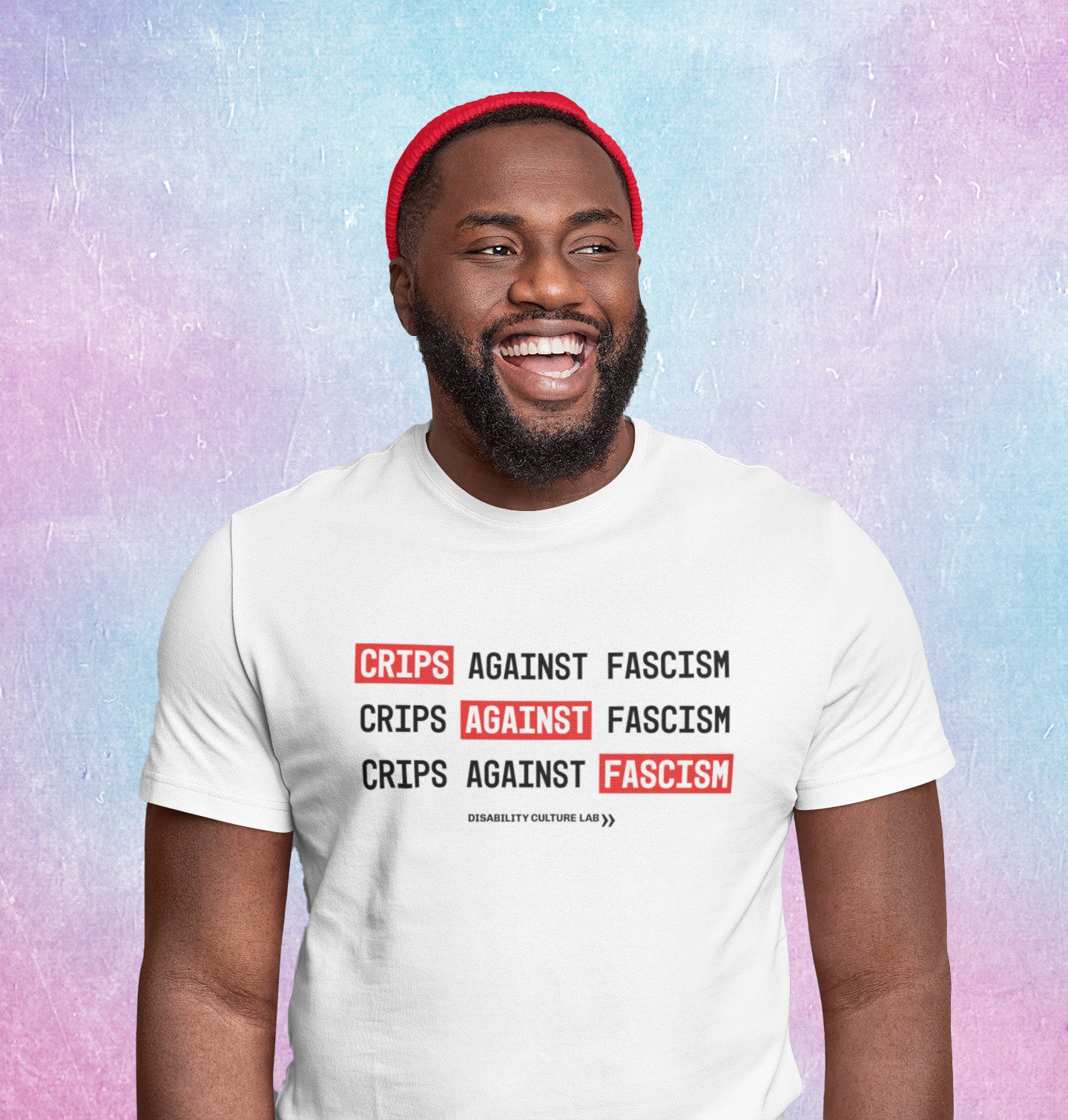 A smiling Black man in a white t-shirt that reads “Crips Against Fascism” three times. 