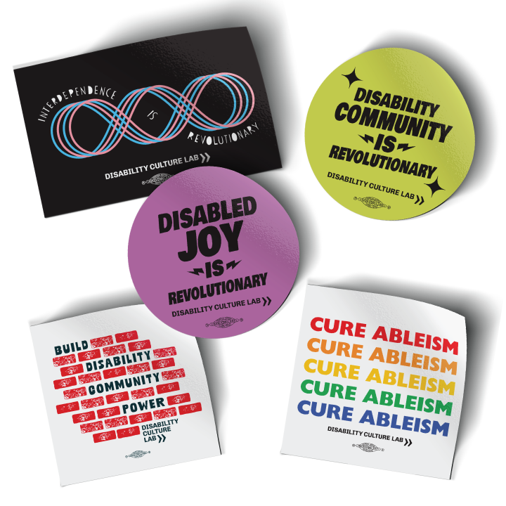 Five stickers on a white background. From left to right, top to bottom: "Interdependence is Revolutionary" sticker in black. "Disability Community is Revolutionary" sticker in yellow. "Disabled Joy is Revolutionary" sticker in purple. "Build Disability Community Power" sticker in white. "Cure Ableism" sticker in rainbow colors on white background.