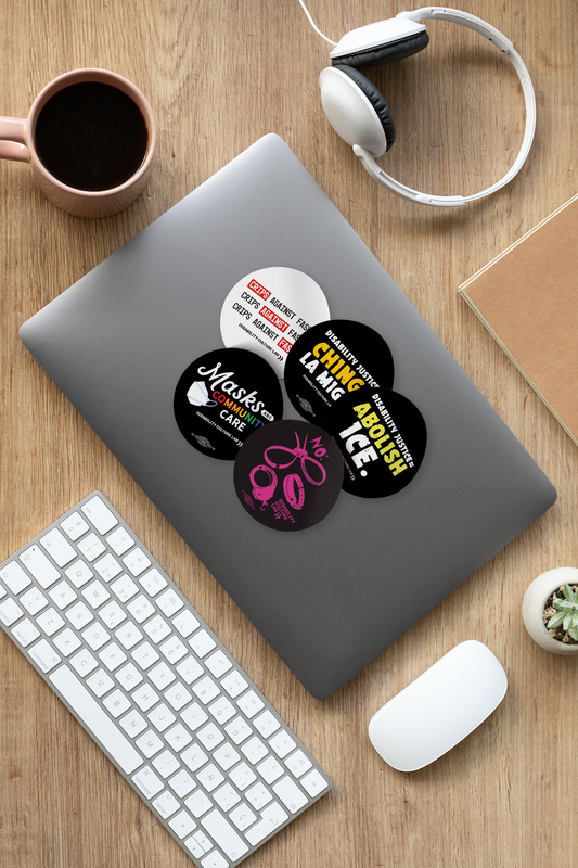 Five circular stickers on a gray laptop. "Crips Against Fascism" on a white background. "Disability Justice = Chinga La Migra" on a black background "Disability Justice = Abolish ICE" on a black background. "Masks are Community Care" on a black background. "NO: Immigrant Detention, Institutionalization, Incarceration" on a black background.