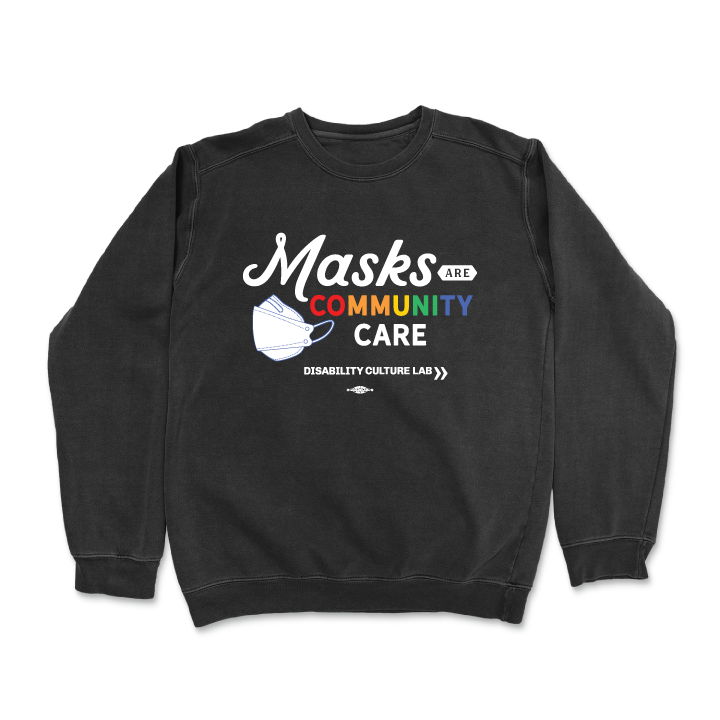 Black crewneck sweater reads "Masks Are Community Care," with "Masks" in a white handwritten font, "Are" in black text in a small white shape, "Community" in rainbow text, and "Care" in white text. To the left of the text is a white KF94 trifold respirator mask. Below is the white Disability Culture Lab logo.